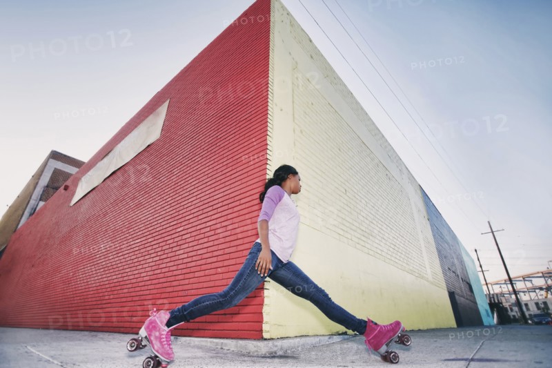 Black woman wearing roller skates gliding around corner