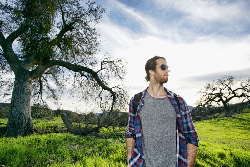Caucasian man standing in field near tree