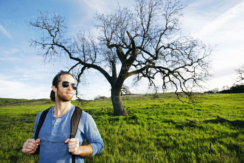 Caucasian man standing in field near tree