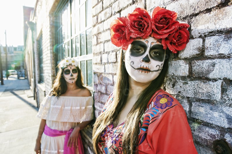 Women on sidewalk wearing skull face paint