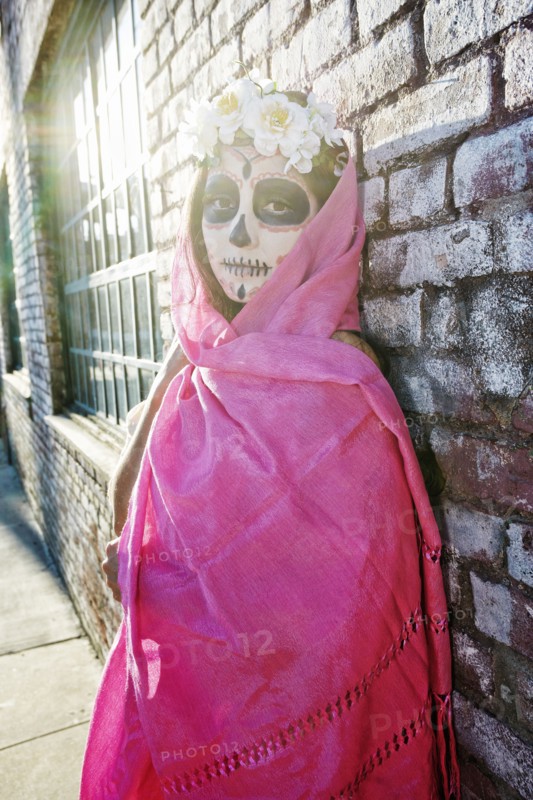 Mixed Race woman wearing scarf and skull face paint