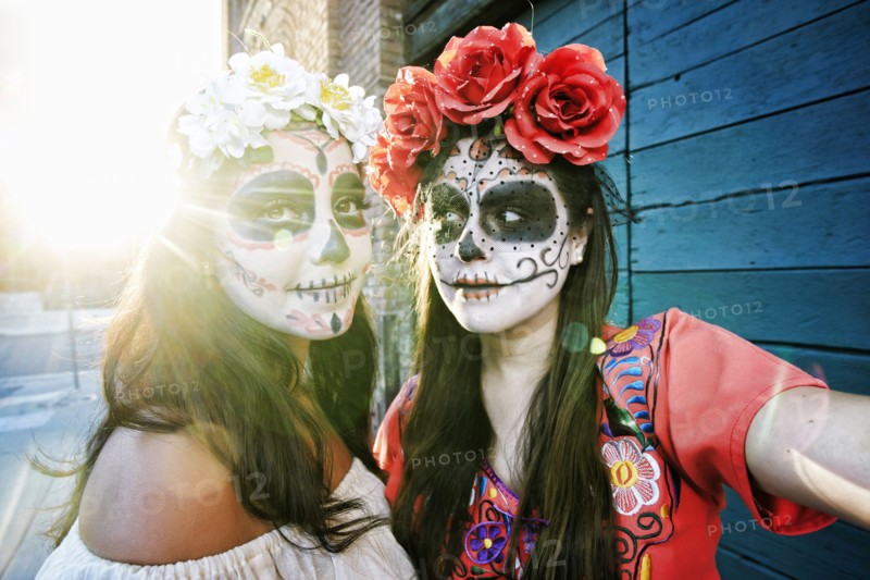 Women on sidewalk wearing skull face paint