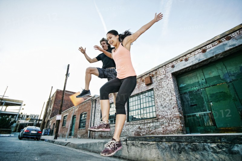 Couple jumping off loading dock
