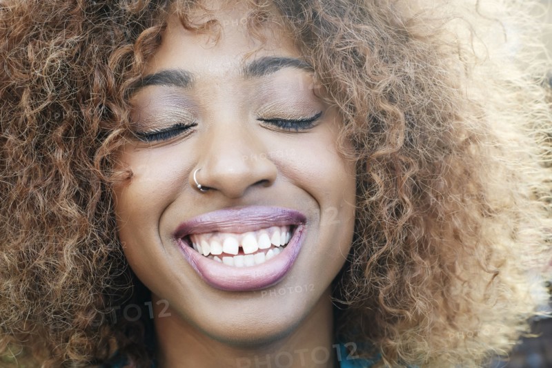 Close up of smiling Black woman with eyes closed