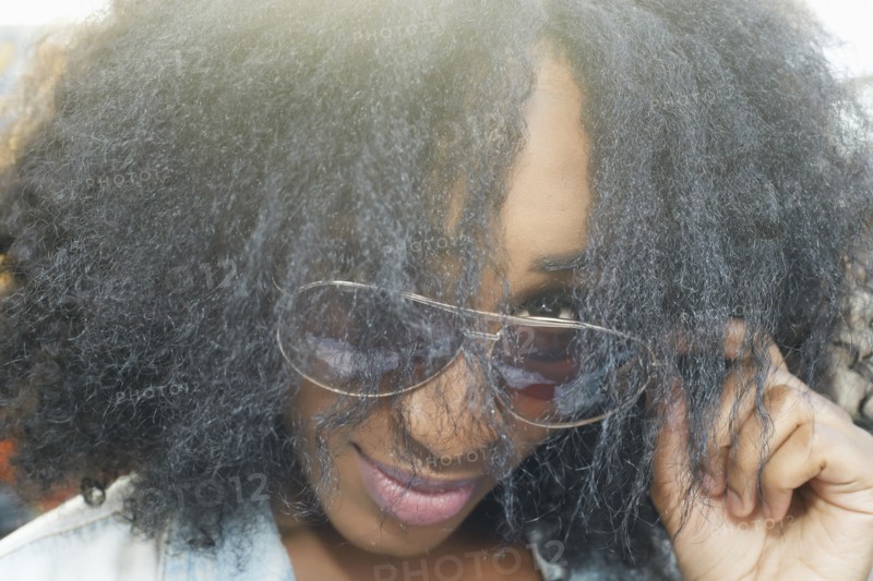 Close up of mixed race woman peering over sunglasses