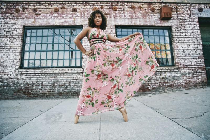 Mixed race ballet dancer wearing dress on sidewalk