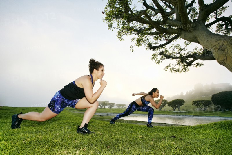 Mixed race women exercising near lake