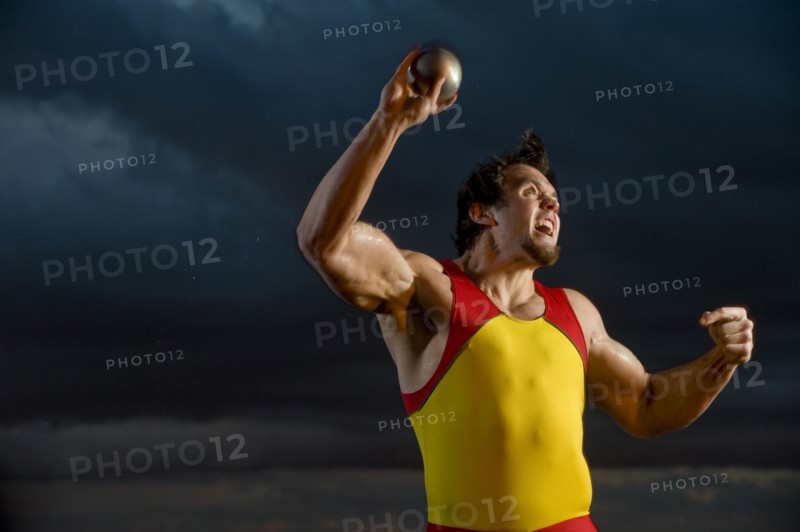 Caucasian athlete throwing shot put