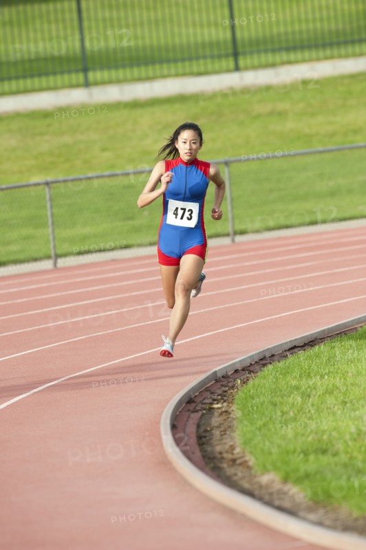 Japanese runner running on racetrack