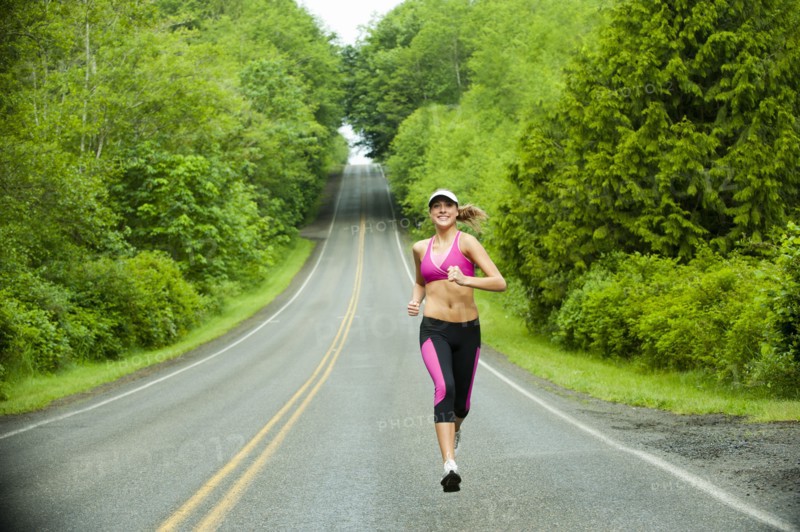 Caucasian woman running on remote road
