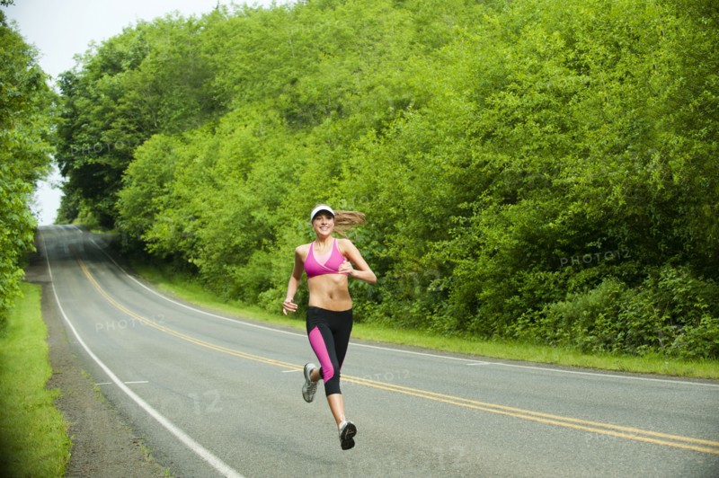 Caucasian woman running on remote road