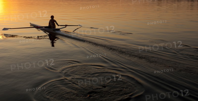 Person rowing sculling boat on river