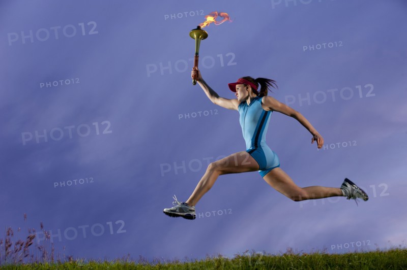 Caucasian athlete running with Olympic torch