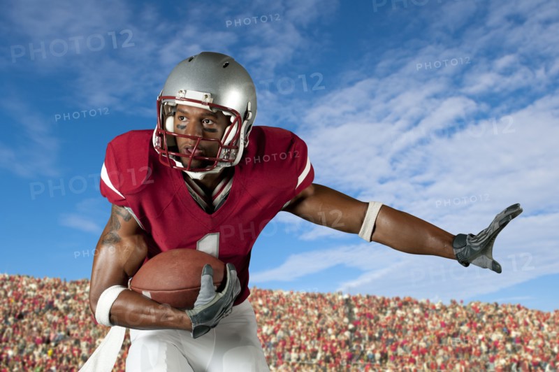 Black football player holding football