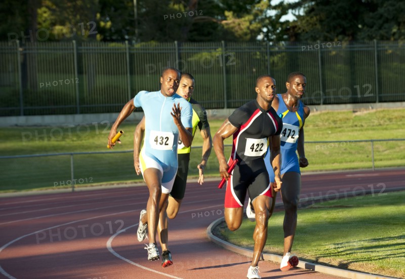 Relay racers running on track in race