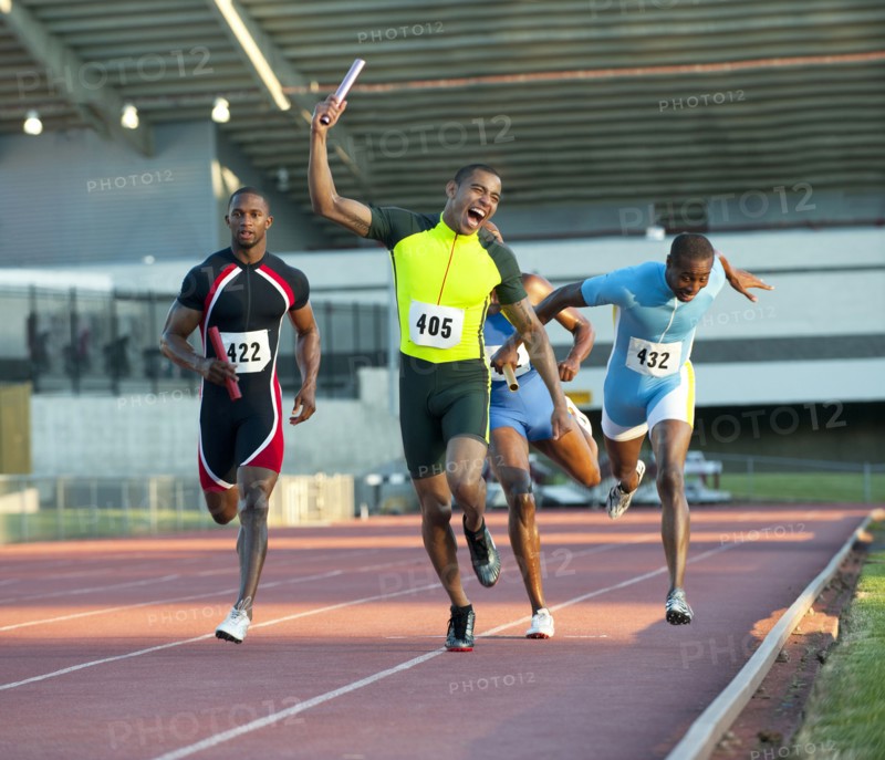 Relay racer crossing finish line on track in race
