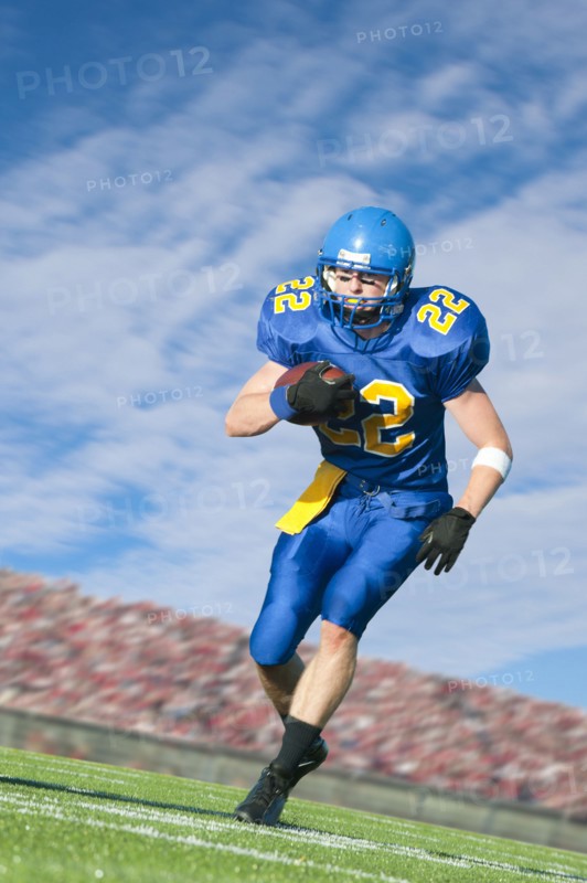 Caucasian football player running with ball