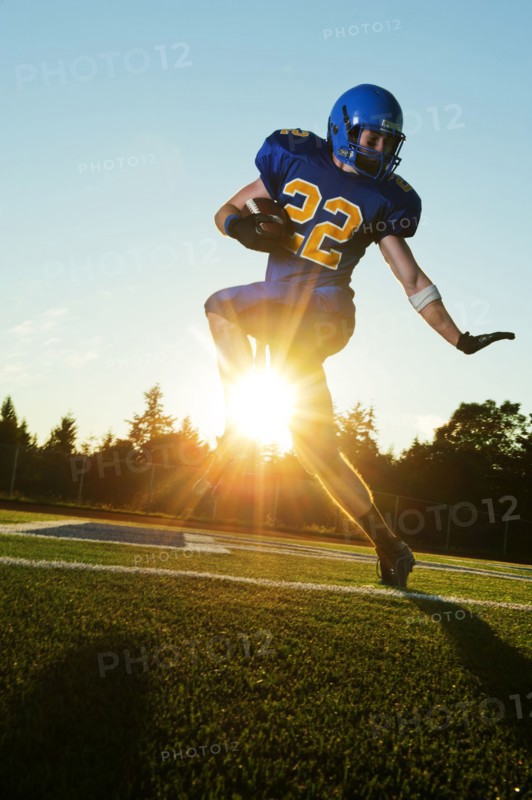 Caucasian football player running with ball