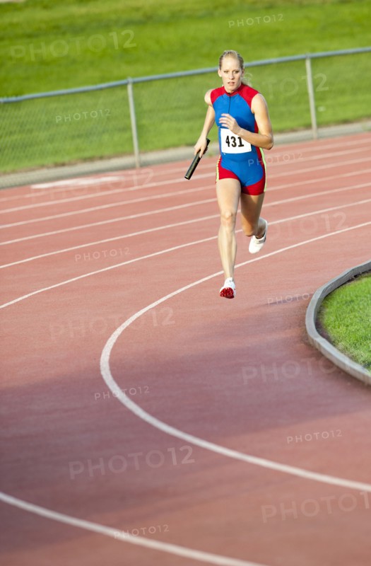 Caucasian runner holding baton running on track