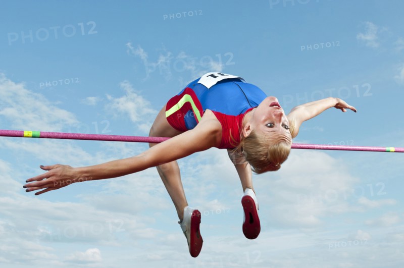 Caucasian athlete jumping over bar