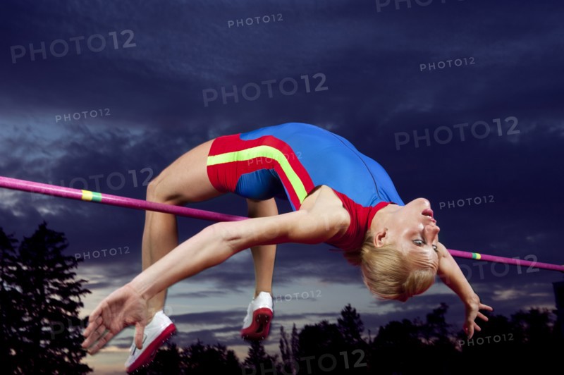 Caucasian athlete jumping over bar