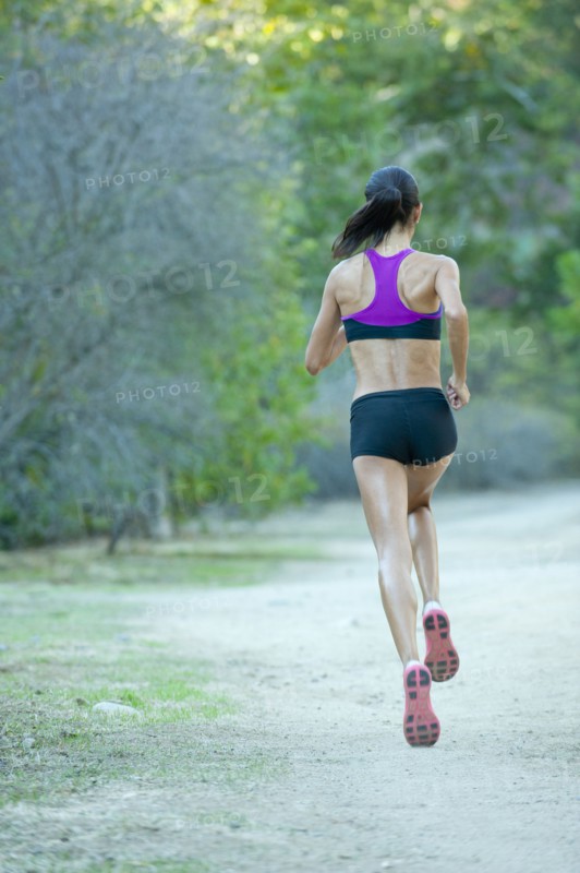 Hispanic woman running on remote path