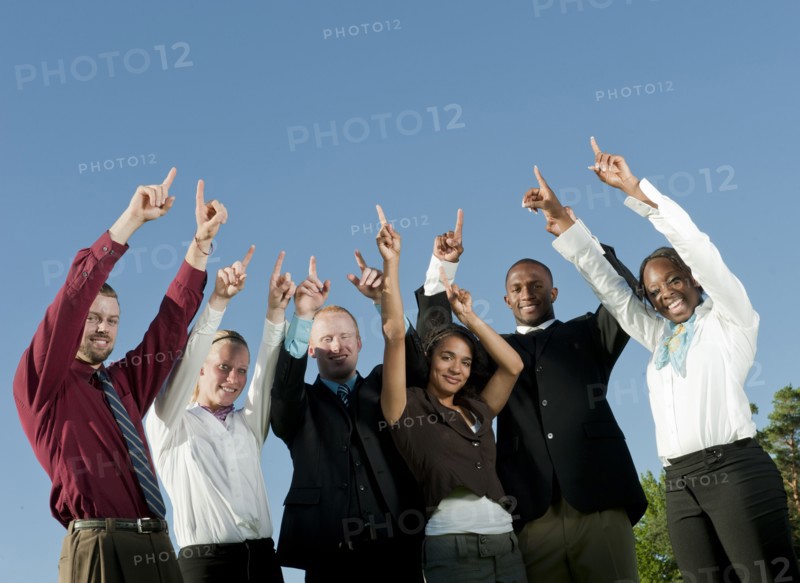 Business people standing together with arms raised