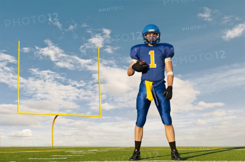 Caucasian football player standing with football