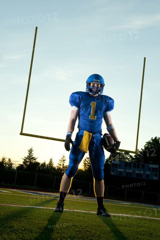 Caucasian football player standing with football