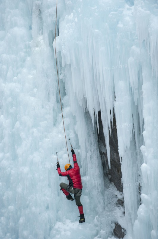 Caucasian man climbing ice wall