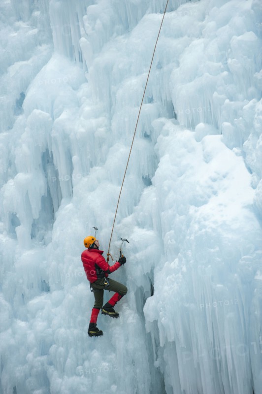 Caucasian man climbing ice wall