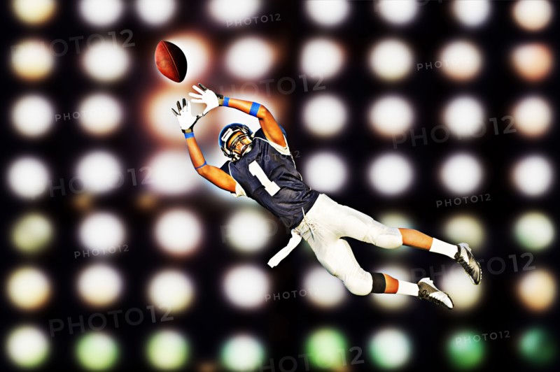 African American football player catching ball