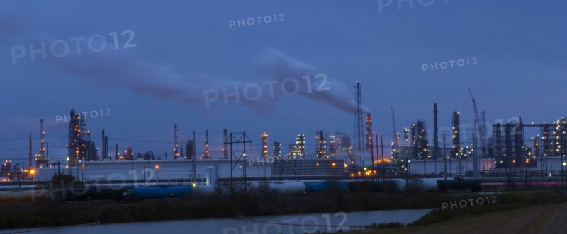 Factory near lake illuminated at night