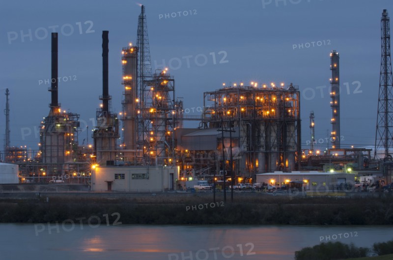 Factory near lake illuminated at night