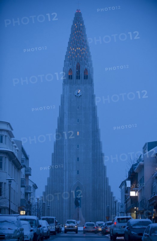 Monument overlooking Reykjavik city street at dusk