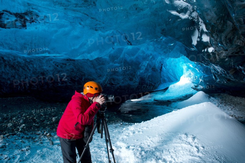 Photographer taking photograph in ice cave