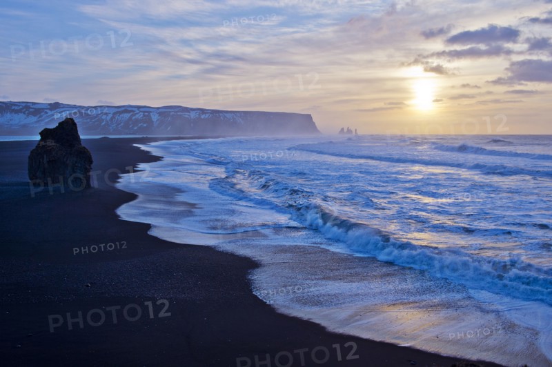 Waves washing up by rock formation on beach
