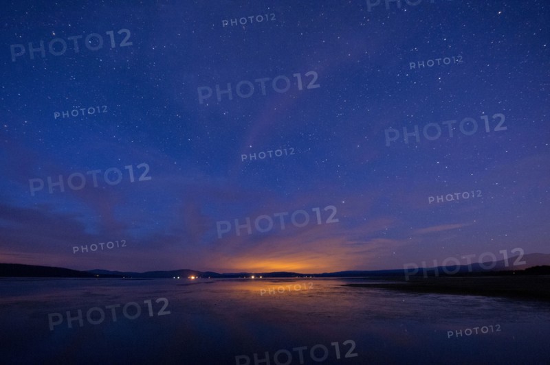 Still rural lake under starry night sky