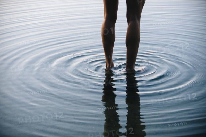 Reflection of legs of Korean woman with ripples in water