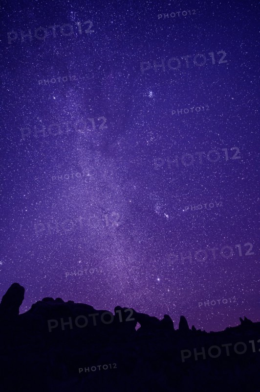 Silhouette of rock formations under starry night sky
