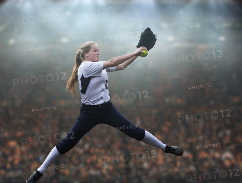 Caucasian softball player pitching ball in stadium