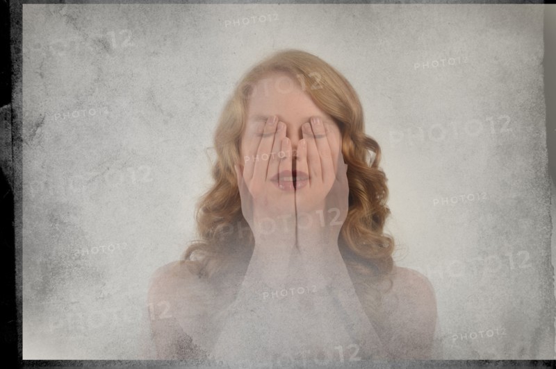 Double exposure of Caucasian woman covering face with hands