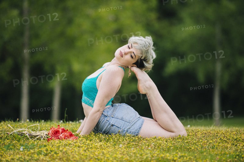 Caucasian woman laying in field arching back
