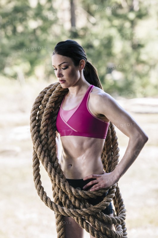 Caucasian woman carrying heavy ropes