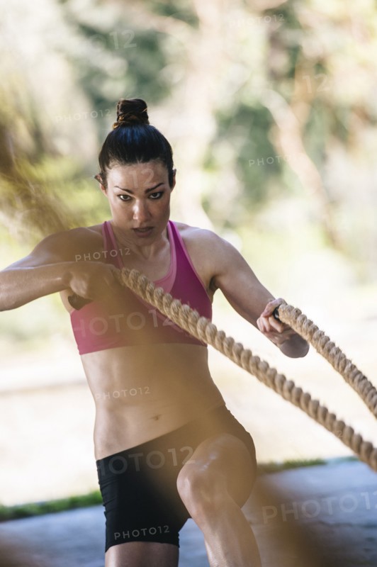 Caucasian woman working out with heavy ropes
