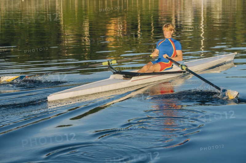 Caucasian man rowing on river