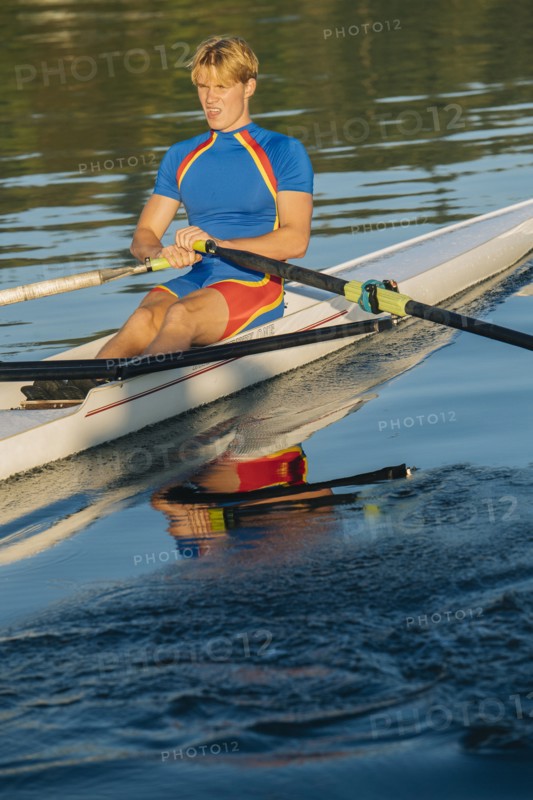 Caucasian man rowing on river