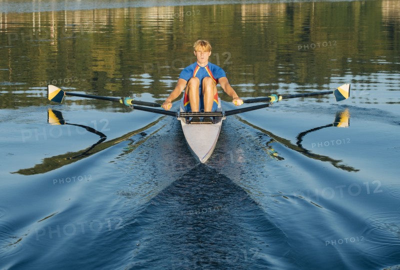 Caucasian man rowing on river