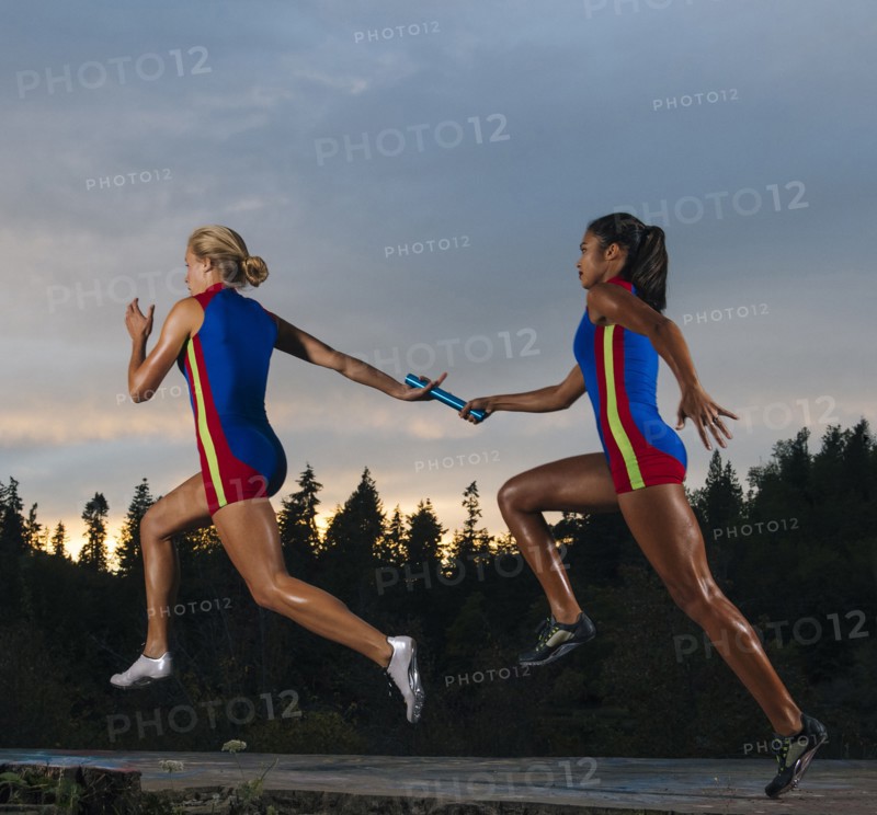 Runners passing baton in race
