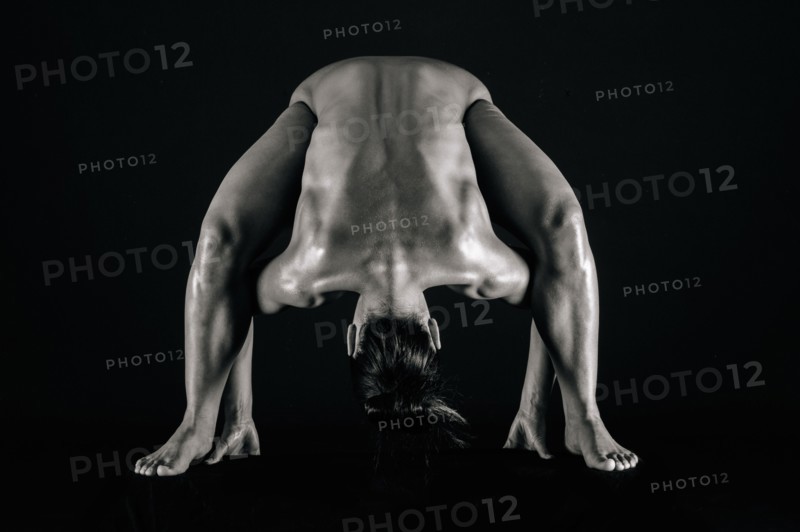 Naked muscular Mixed Race woman bending forward